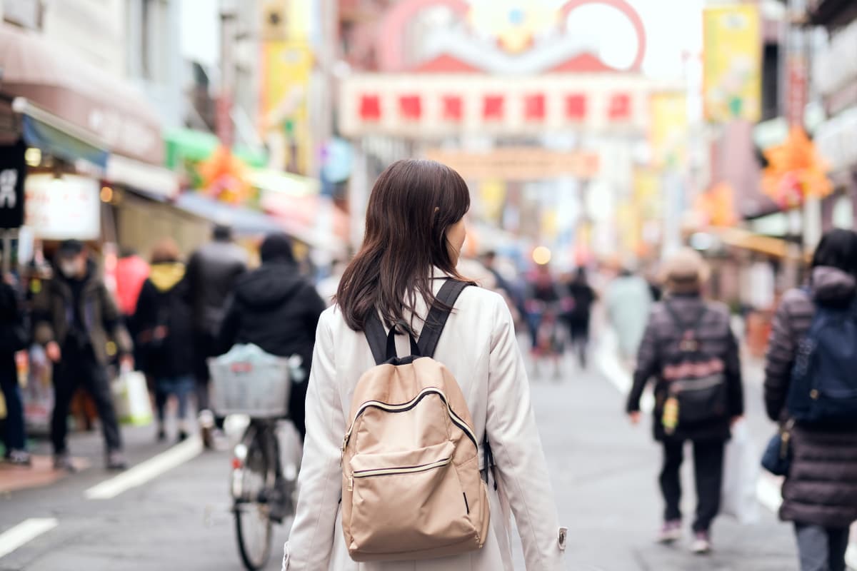 賑わう商店街を歩く女性の後ろ姿