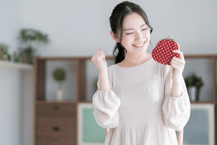 財布を持って笑う女性