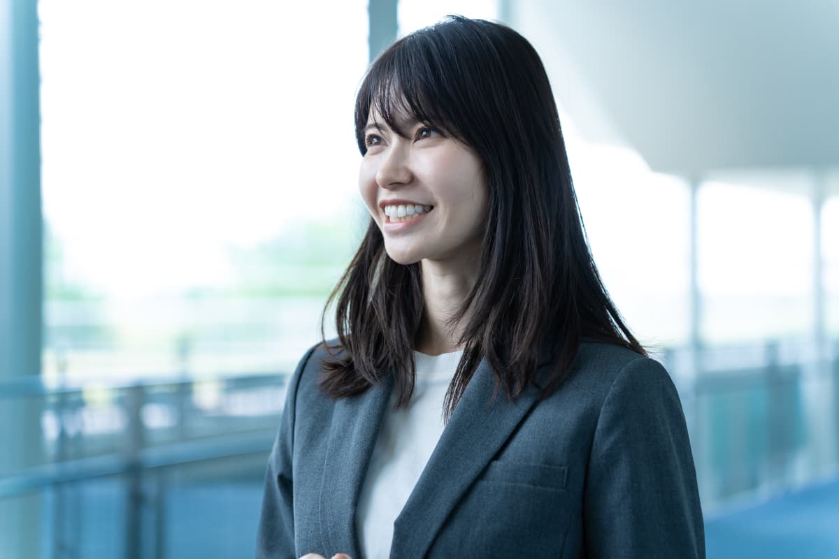 室内で話をするスーツを着た日本人男女