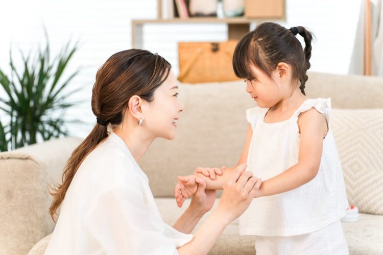 娘の手を握るお母さん