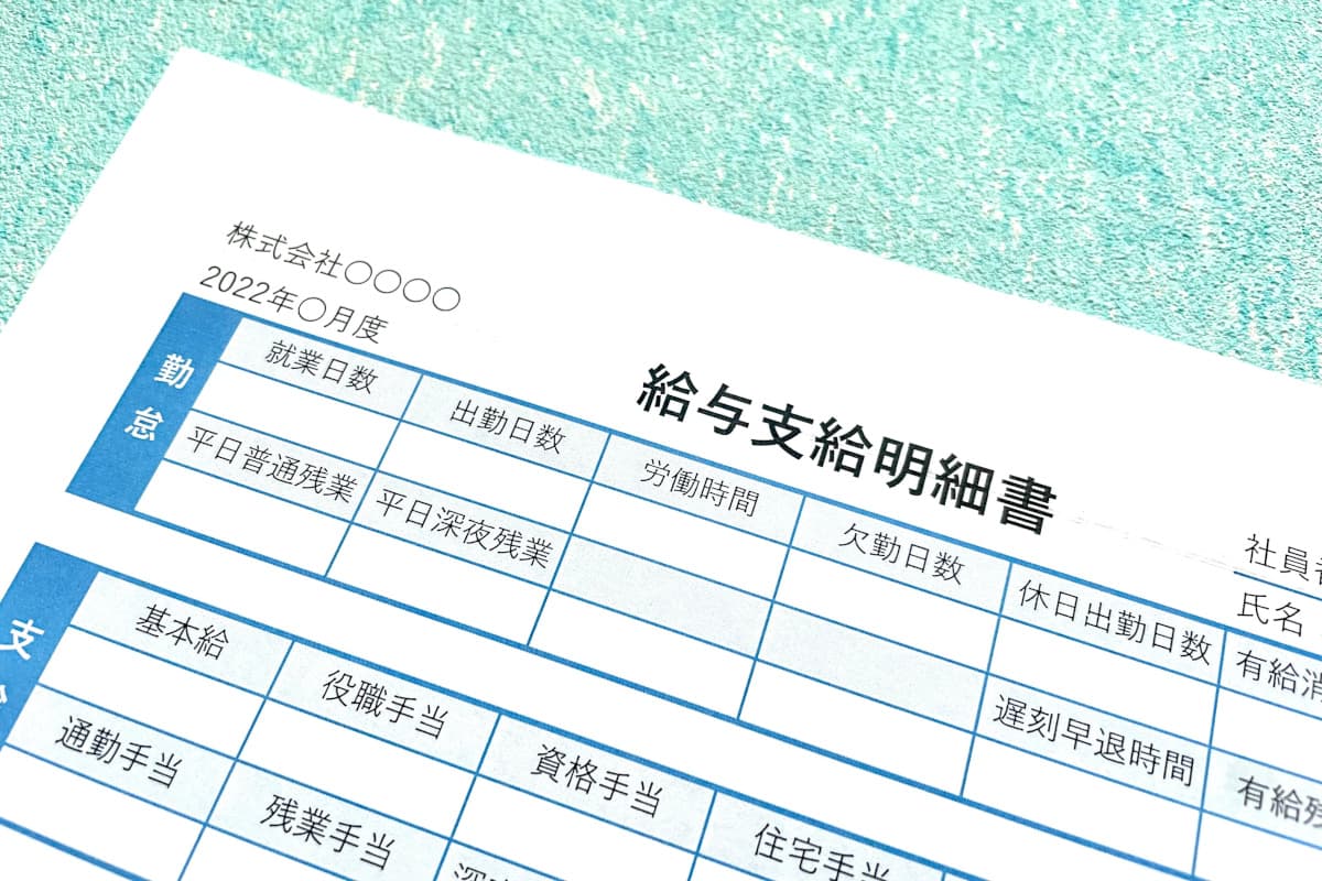水色のテーブルの上に置かれた給料明細