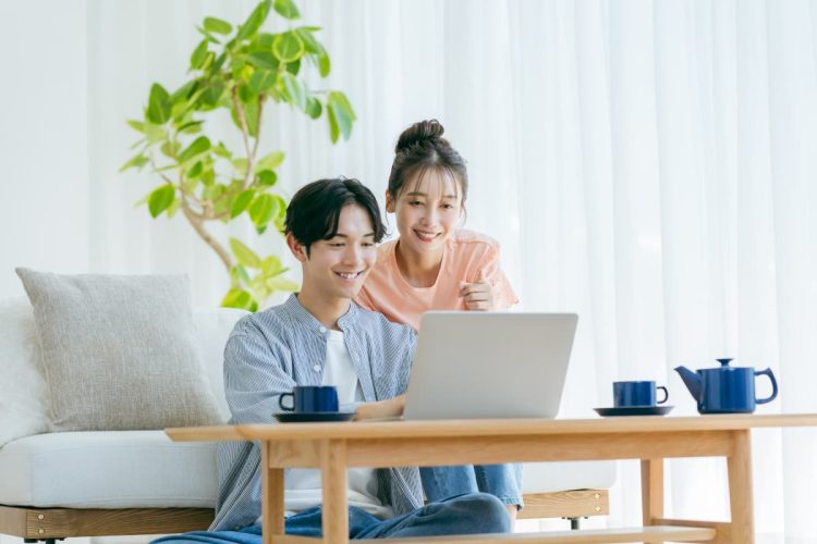 自宅でパソコンを見る夫婦