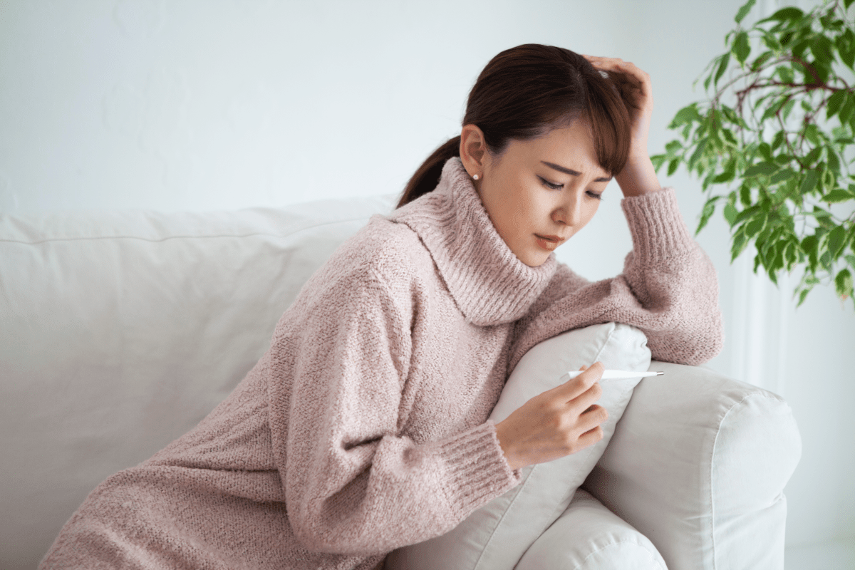 発熱して頭を抱える女性