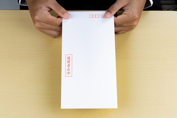 履歴書の入った封筒を渡す人