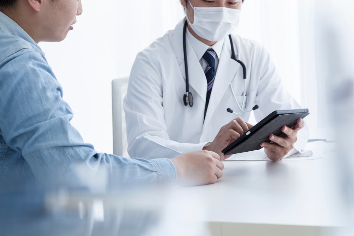 病院で医師から診察を受ける男性