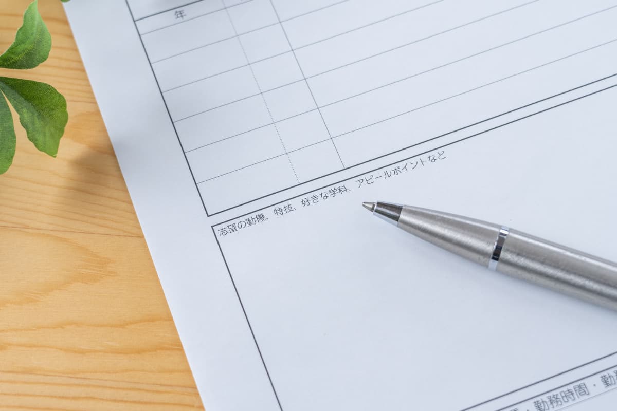 テーブルの上に置かれた履歴書とボールペン