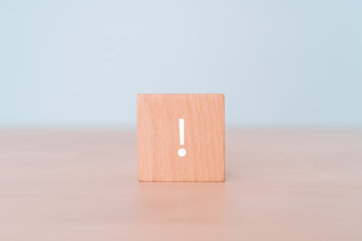 テーブルの上に置かれた！マークの木のブロック