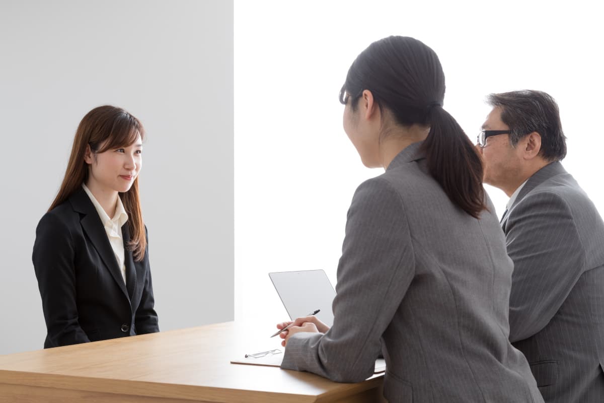 面接で志望動機を答える女性と話を聞く面接官