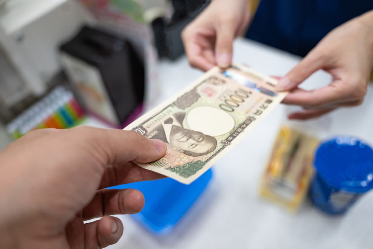お客様からお金を受け取るコンビニスタッフ