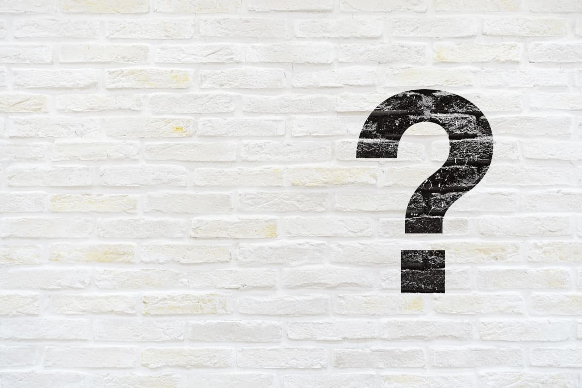 白いレンガの壁に描かれた大きなクエスチョンマーク