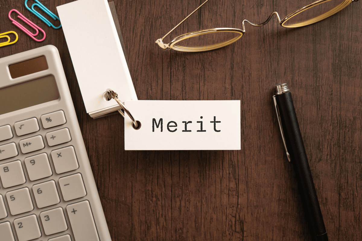 メリットと書いた札と文房具