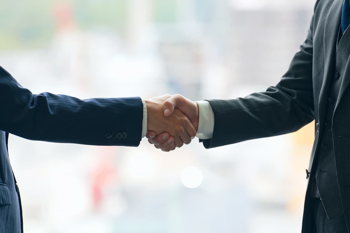 契約成立し、握手をするビジネスマン