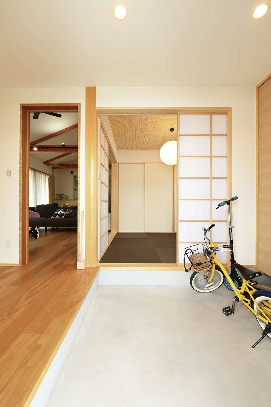 Yamaguchi Design 【自然素材、間取り、スキップフロア】玄関は昔の民家の寄り合い土間のように、誰もが気軽に立ち寄って床に腰かけ、ゆっくり話ができる空間をデザイン。土間は自転車を置いても余裕の広さ