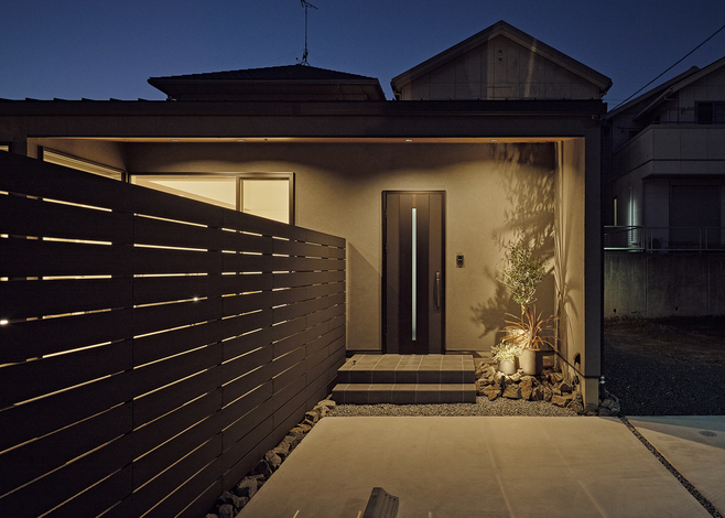 照明でグレーの塗り壁の質感が際立つ玄関