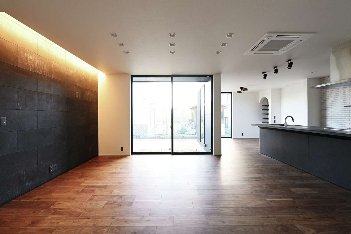 REIWA HOUSE（令和ハウス）【デザイン住宅、省エネ、間取り】建物をL字型に配置し、中庭からたっぷりの光を取り入れる。エアコンを天井にビルトインしたことで、空間をすっきりと。黒い石のテレビステーションが空間を引き立てる
