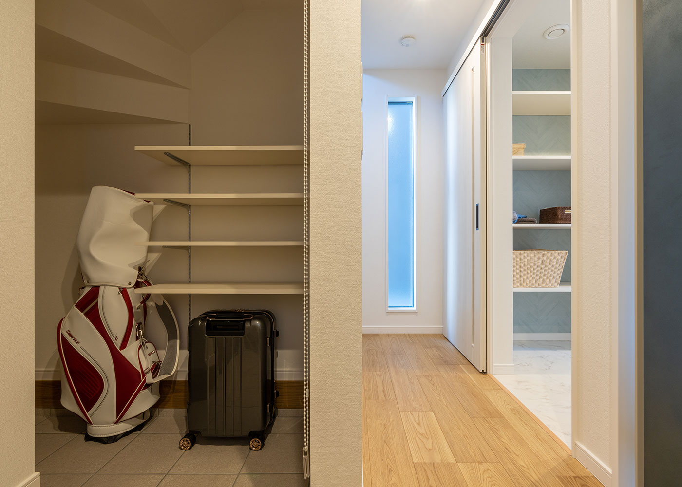 寺田工務店【収納力、狭小住宅、省エネ】階段下のスペースを土間収納に活用し、収納力をさらにアップ。ご主人の趣味のゴルフやサーフィンの道具もすっきり収納できる。ロールスクリーンを下ろすだけで生活感がなくなるので、来客時も気にならない