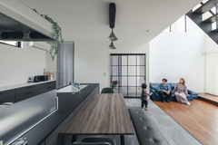 吹き抜けのリビングとは対照的に、ダイニングキッチンは天井高を低めにし、独特の落ち着きが生まれた。グレーで統一したシンプルな空間に、ペンダント照明やアイアンの格子窓がアクセント的な役割を果たしている