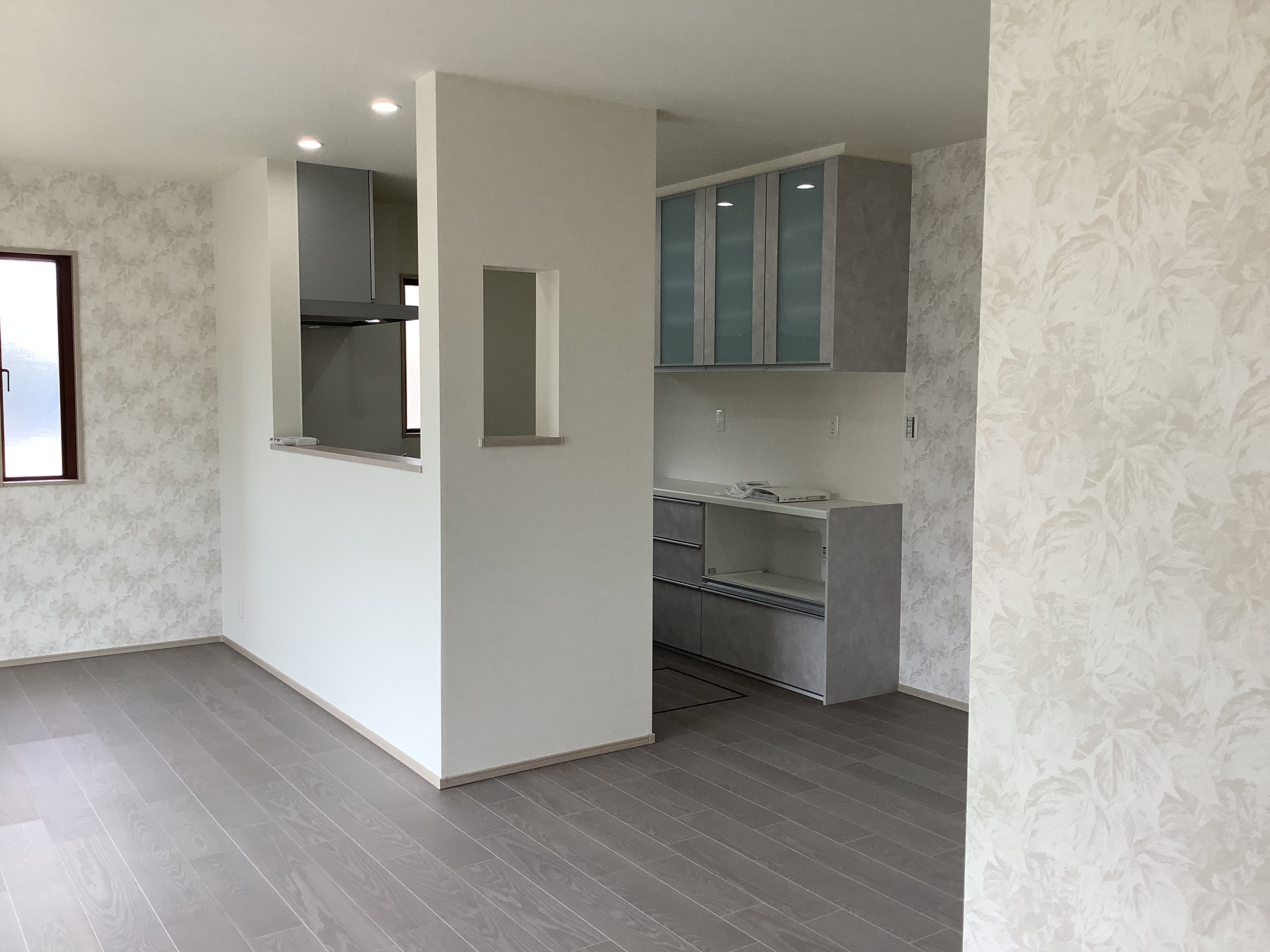 フロート・ハウス｜シンプルで広々としたLDKスペース。壁でキッチンとダイニングエリアを分けることで、プライバシーを確保しつつも開放感を意識したデザインになっている。