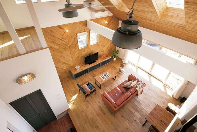 勾配天井のトップライトが、開口部を減らした通り側まで明るさを招く。テレビの背後はあえて板を斜めに張り、視線を落ち着かせた。テーブルやテレビボードもオリジナル。雰囲気にマッチしつつ、異素材／異色の組み合わせが空間のアクセントになっている