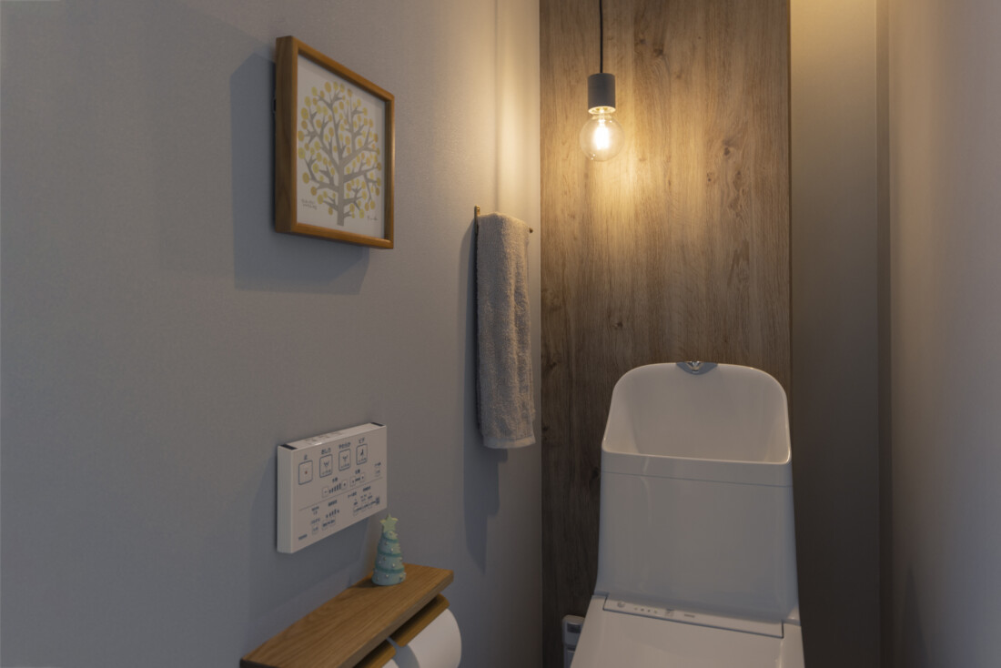 チェックハウス｜落ち着いた色調のトイレ空間。壁に掛けられた絵や小物がアクセントとなり、温かみのある雰囲気が漂っている。