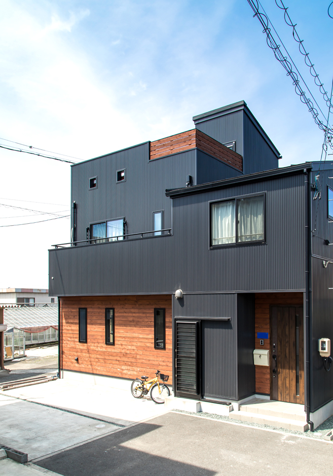 東海ハウス【1000万円台、屋上バルコニー、間取り】黒ガルバリウムの外壁はご主人の希望。レッドシダーの板壁を組み合わせてスタイリッシュに仕上げた