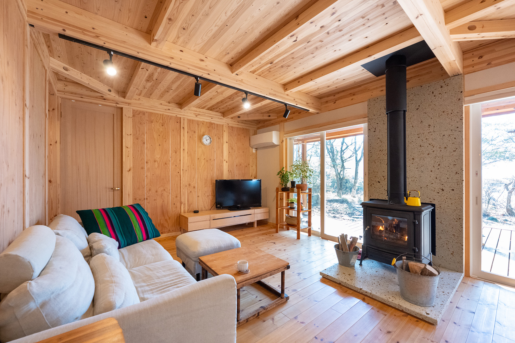 ネクストハウスデザイン｜木の温もりが感じられるリビングスペースでは、薪ストーブが風情を引き立て、落ち着いた空間でリラックスできるようになっている。