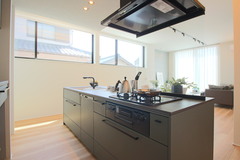 明るい日差しが降り注ぐアイランドキッチン。シンプルでモダンなデザインが特徴で、開放感のある空間を演出している。