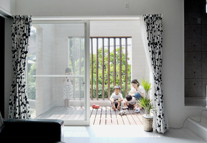 リビングからフラットにつながる大きなウッドデッキ。木の格子で目隠しできるので、視線を気にすることなく、BBQや子どもプールを存分に楽しめる