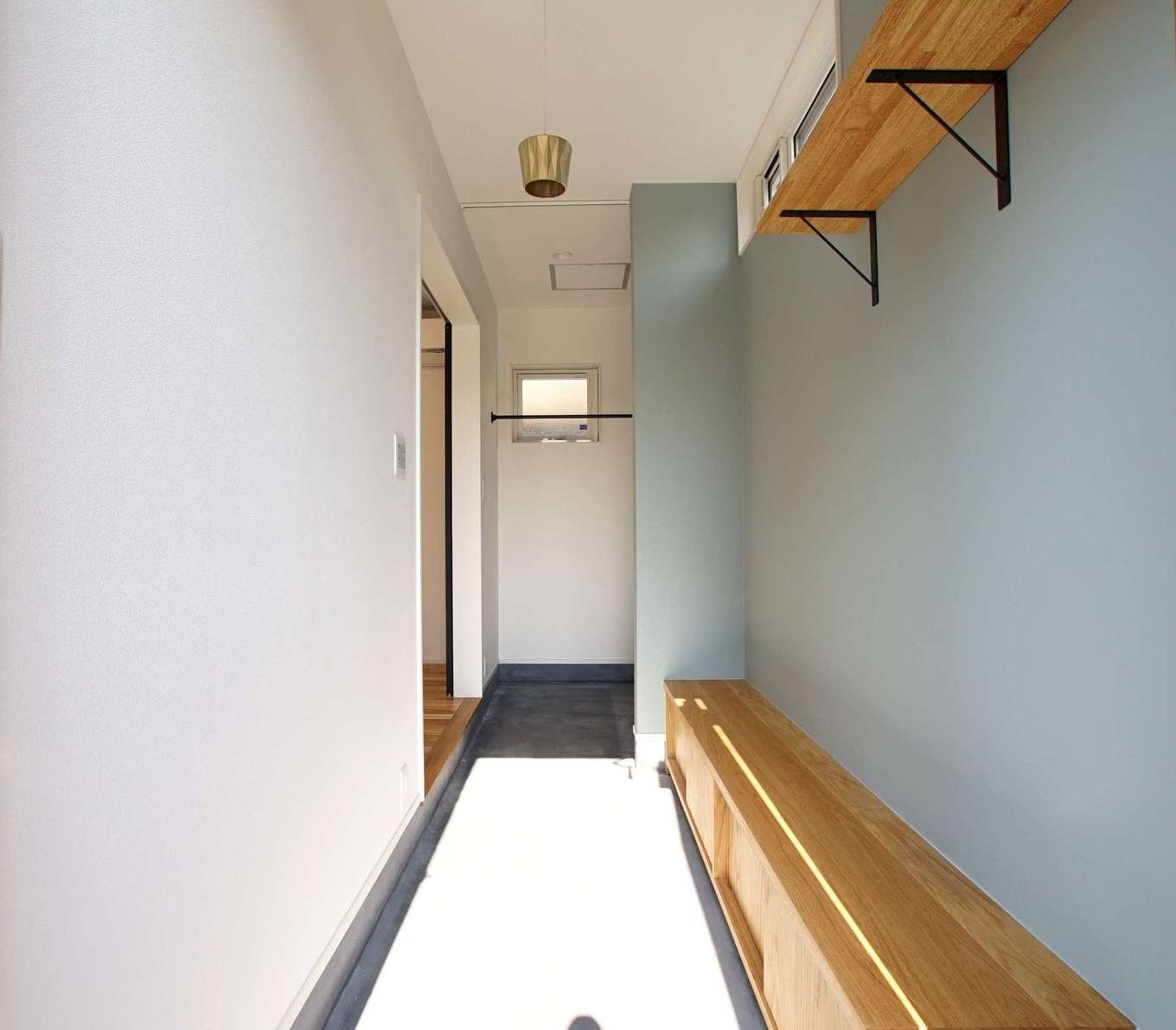 RIKYU 一級建築士事務所【収納力、間取り、建築家】たくさんの靴やキャンプ用品などをしまえる土間収納付き玄関。壁一面に貼ったアクセントクロスと同じ色のクロスやタイルを家中の至る所に使用した