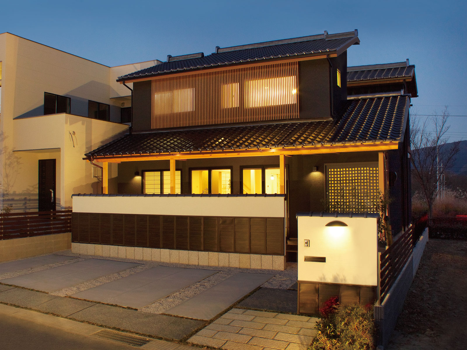 ヘスタホーム｜夜の静寂に溶け込む住宅の外観。暖かい光が窓から漏れ、伝統的な和風のデザインが温かみのある雰囲気を醸し出している。