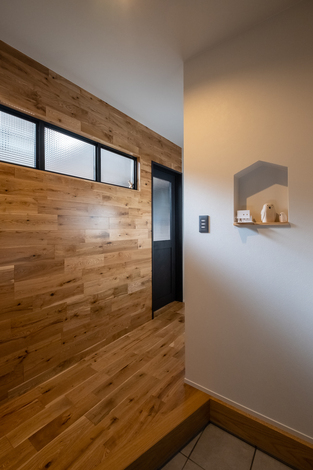 家の形のニッチが可愛い玄関。玄関だけでなく、床と壁はオークで統一した