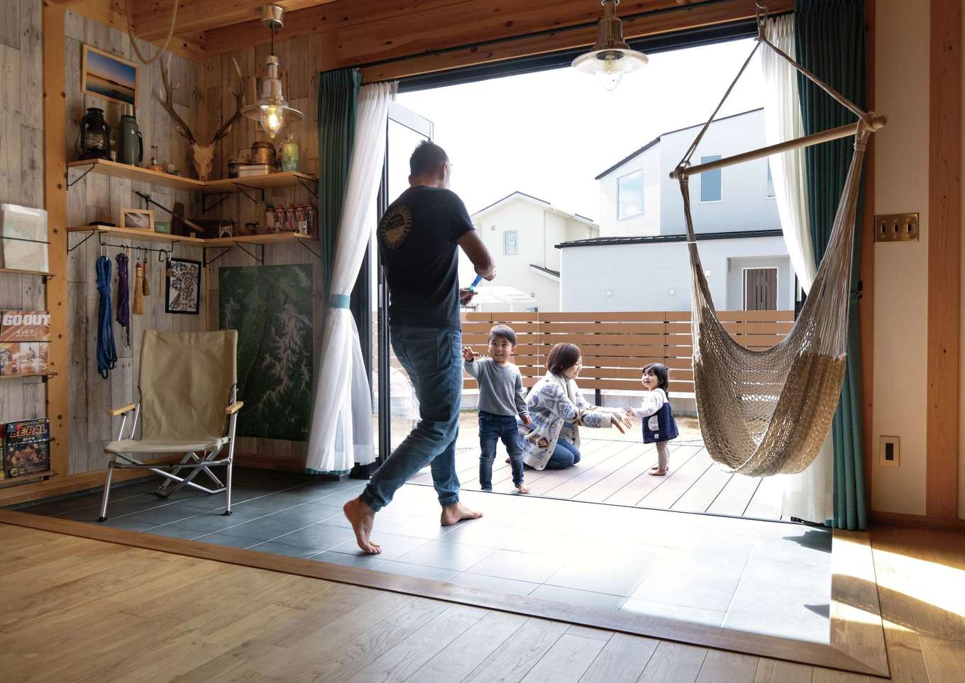 サイエンスホーム【子育て、趣味、自然素材】フルオープンの窓を開け放てば、デッキや庭までリビングの一部となり、出掛けなくてものびのび過ごせる。造作の棚やマガジンラックもイメージ通り。夜もいい雰囲気