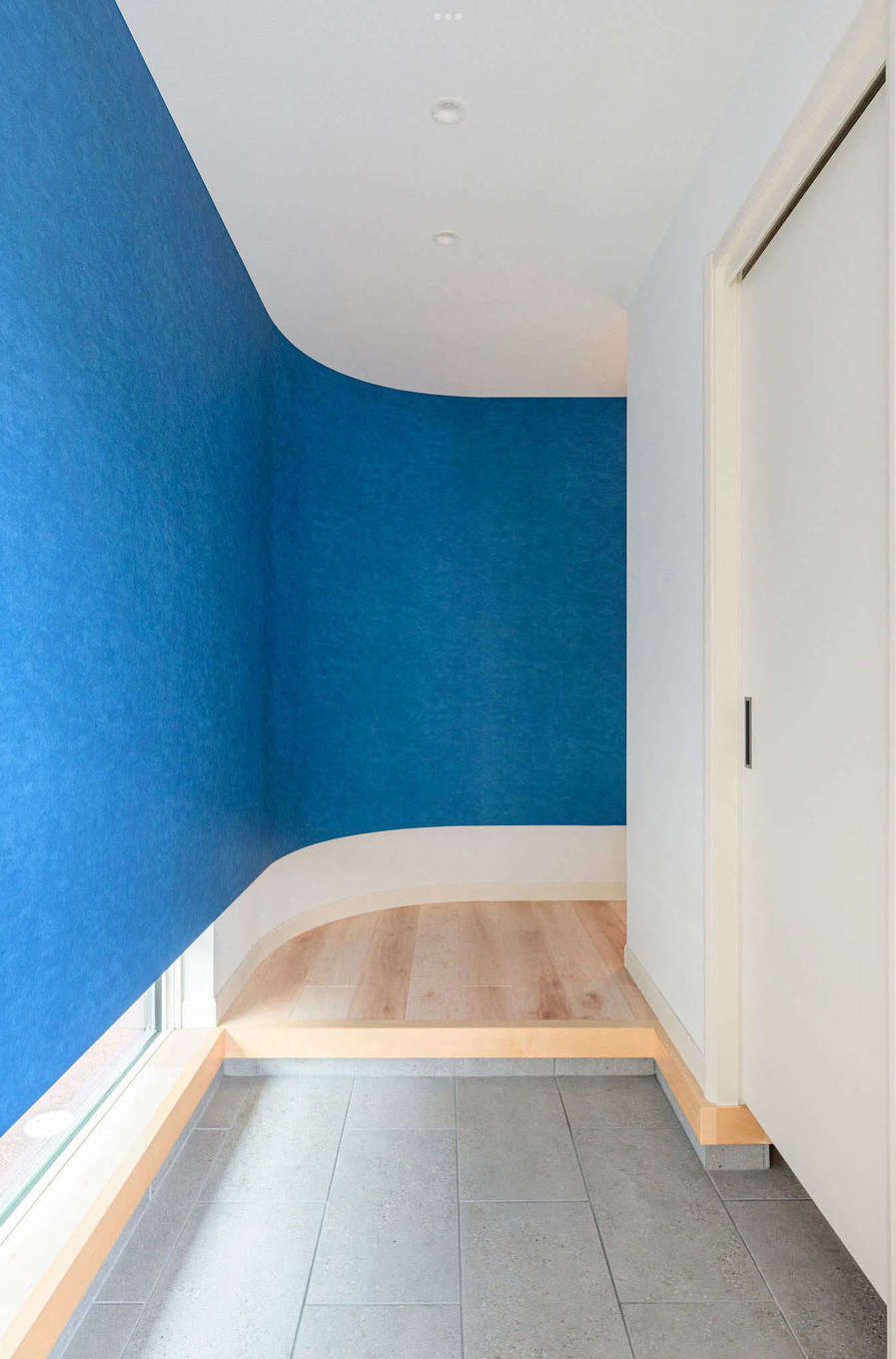 三井ホーム　静岡支店・静岡東支店【デザイン住宅、趣味、間取り】カーブを描くように計画したブルーの壁が印象的な玄関ホール。来訪者に大きなインパクトを与えてくれる