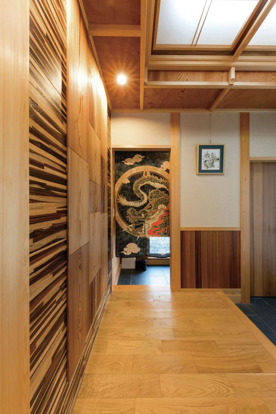 櫻 工務店【和風、自然素材、間取り】玄関ホールは、ヒノキ柱にケヤキの折り上げ天井…と木組みを現した贅沢なつくり。アーティスティックな壁は、秋田スギとローズウッドをそれぞれ特殊加工したもの