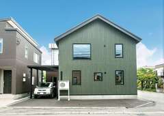 三角屋根のシンプルな外観フォルム。夫婦の好きな深いグリーン系のサイディングにブラックの窓枠が映える