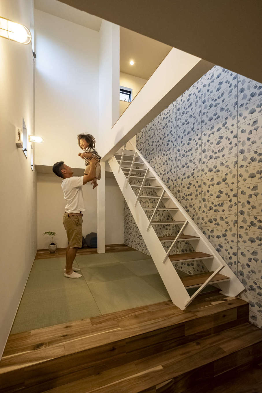 Hands Works（アオイ建築）【子育て、自然素材、インテリア】階段下のデッドスペースを活かして作ったスキップフロアの畳コーナー。白く塗装した鉄骨階段と輸入クロスで軽やかな雰囲気に