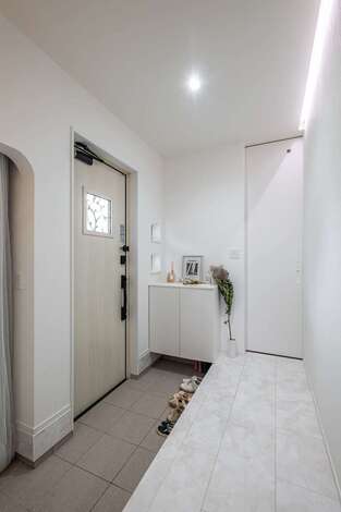 玄関は大理石調フローリングに。左手は機能的なシューズクローク