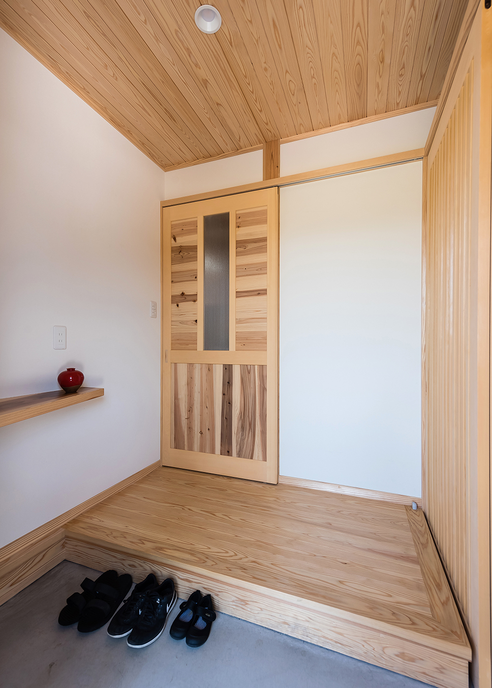 アクトホーム【収納力、自然素材、省エネ】玄関を入った瞬間に、造作の扉やカウンターが目をひく。右手には土間収納も