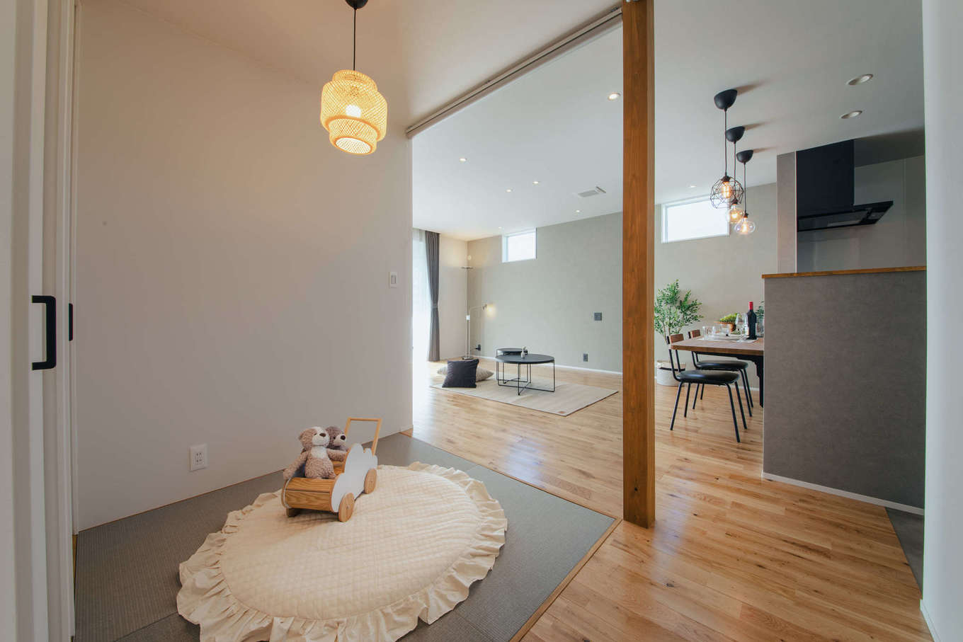 DAITOKU（大得工務店）【デザイン住宅、子育て、間取り】キッチンから目が届く位置に畳コーナーを配置。子どもの様子を見守りながら料理できるので安心だ。ロールスクリーンを下ろすだけで、子どもが静かに寝られるお昼寝コーナーにもなる