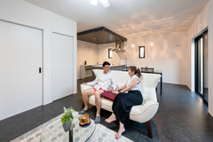 華美な装飾を避け、白とグレージュでセンス良くコーディネートしたLDK。キッチン部分の下がり天井が空間を緩やかにゾーニングし、ペンダントライトがニュアンスを添える