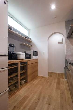低燃費住宅静岡® TK武田建築｜シンプルな食器棚に、お気に入りのうつわを収納。調理器具を支える天板は造作。パントリーの垂れ壁をアーチ形状にしてニュアンスを出した