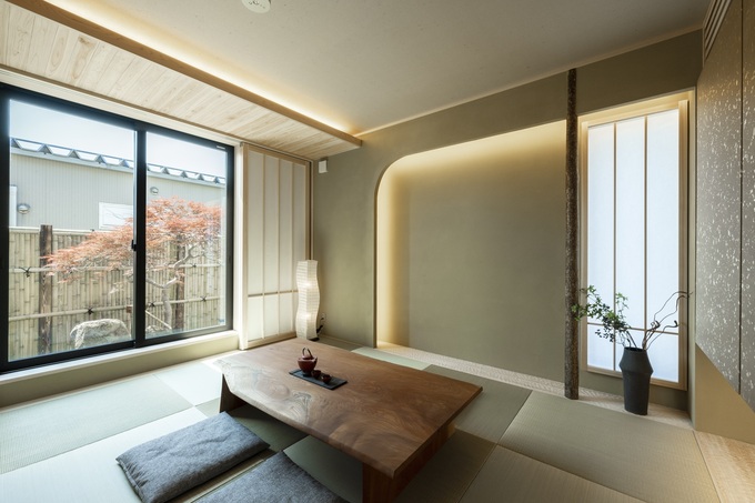 落ち着いた雰囲気の和室。大きな窓から自然光が入り、畳の温もりを引き立てている。現代的なデザインと伝統が調和した空間。