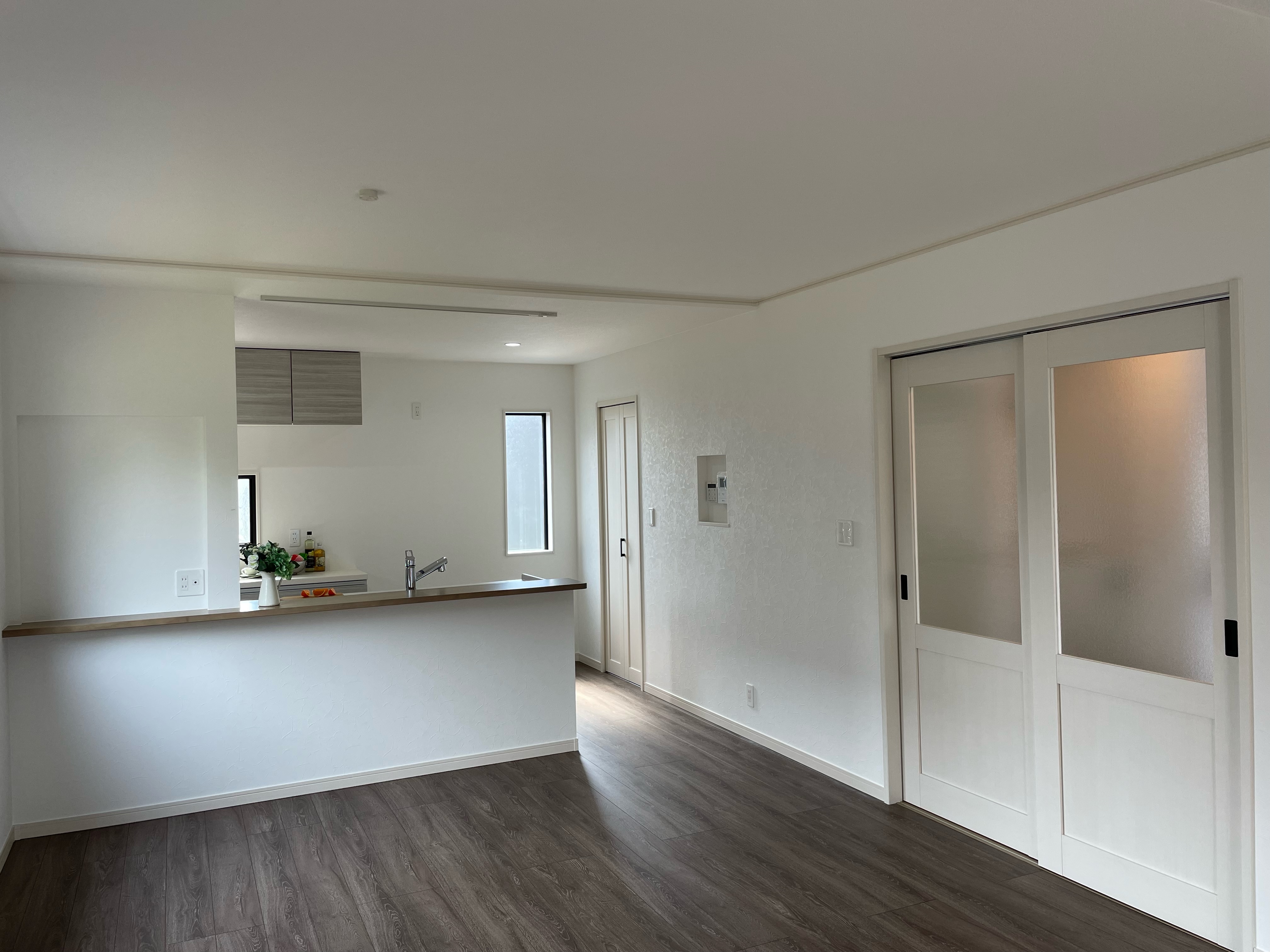 タムラ建築設計｜広々としたLDKはシンプルでモダンなデザインが特徴。白を基調とした内装が、清潔感と開放感を演出している。