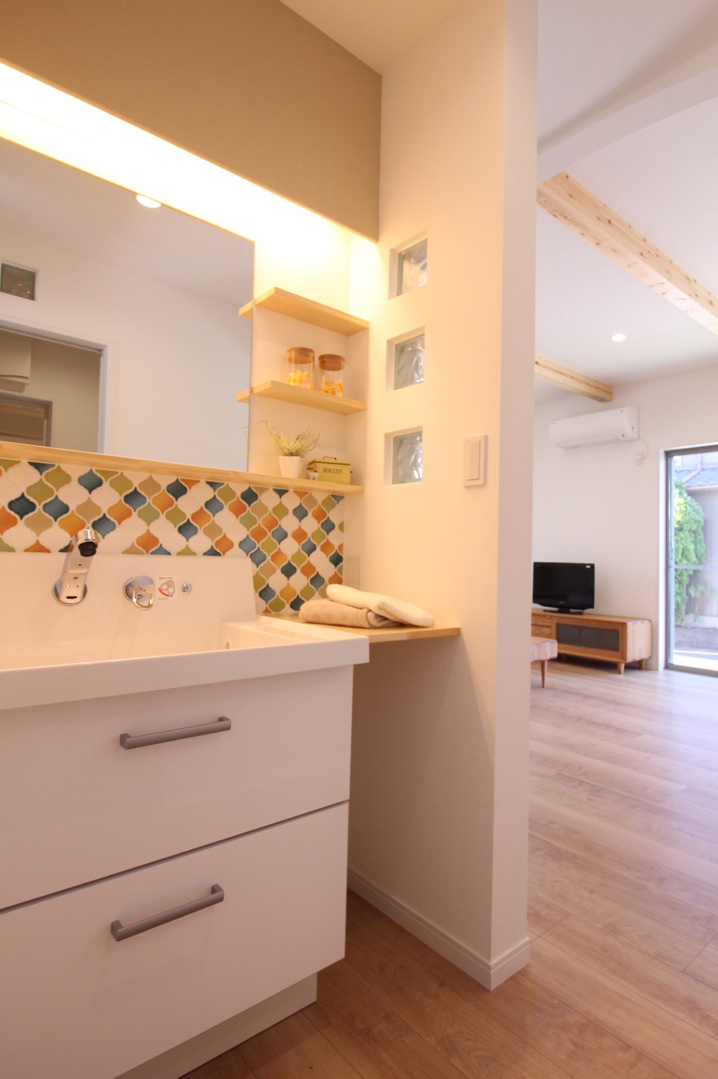 小野田産業～designers house project～｜カラフルなタイルが特徴的な洗面スペース。収納棚は小物の整理に便利で、全体のデザインにアクセントを加えている。