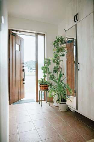 子育て安心住宅 Design Craft Office｜南側に設けた明るい玄関。天井いっぱいまで確保した玄関収納は、姿見付きで使い勝手も便利
