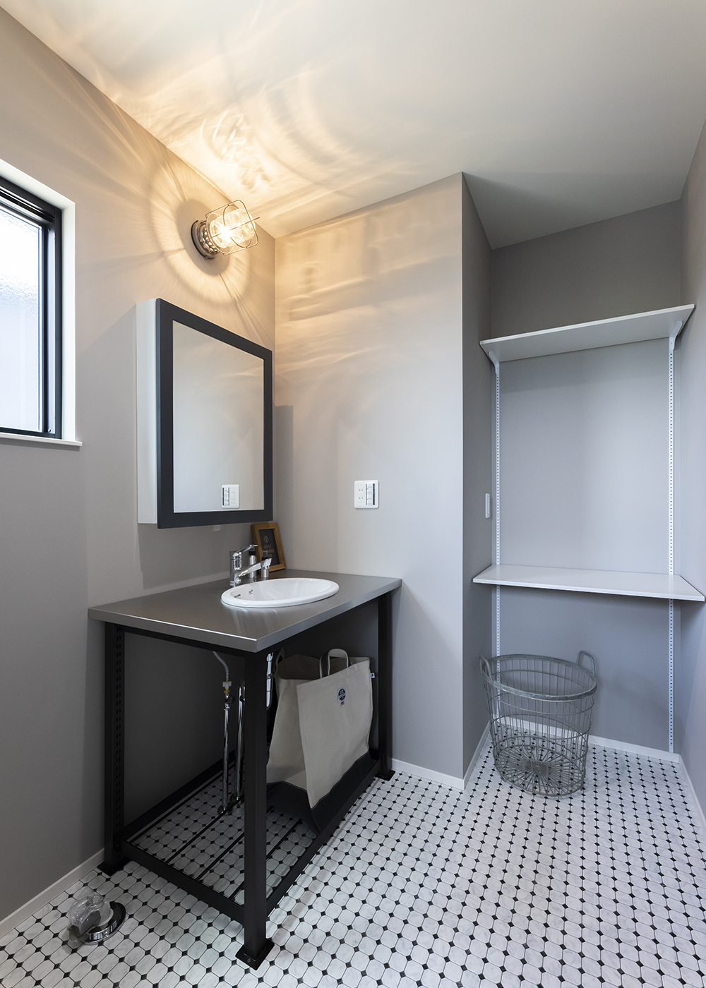 大和建設／BinO西尾南【デザイン住宅、インテリア】グレーと黒で統一したランドリー。アメリカンなステンレストップの洗面台は、掃除が楽にできる。オリジナルミラーには収納棚が備わっている