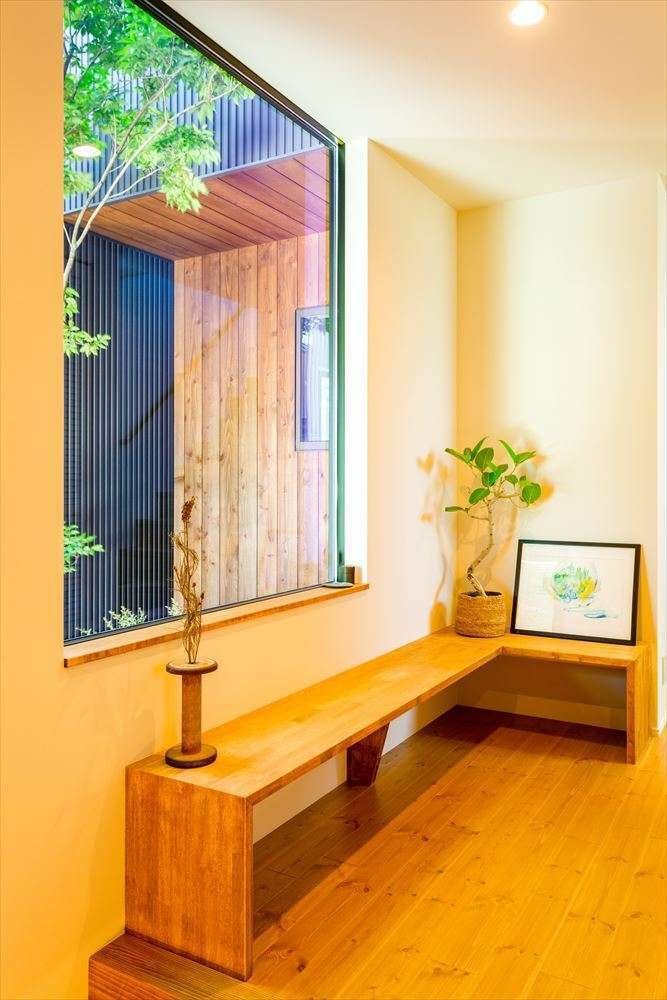 温戸ライフ【自然素材、狭小住宅、間取り】大きなFIX窓に映る坪庭の景色は、額縁に切り取った一枚の絵のよう。造作ベンチの佇まいにもホッと癒やされる