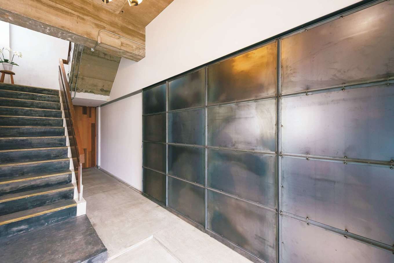 建杜 KENT（大栄工業）｜2階ホール。鉄板を4枚組み合わせて加工し、土間の入口となる引き戸に仕上げた