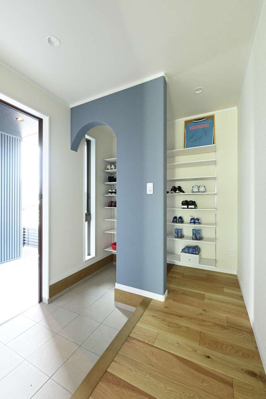 Yamaguchi Design 掛川店（アイフルホーム 掛川店）【デザイン住宅、子育て、間取り】シューズクローク付きの玄関は、グレーの壁とアール型の出入り口がポイント。クローク内部にもスリット窓を用意して採光を確保。明るくて清潔感がある