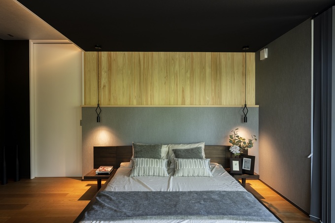 モダンで落ち着いた雰囲気の寝室。シックな色調と間接照明が、リラックスできる空間を演出している。